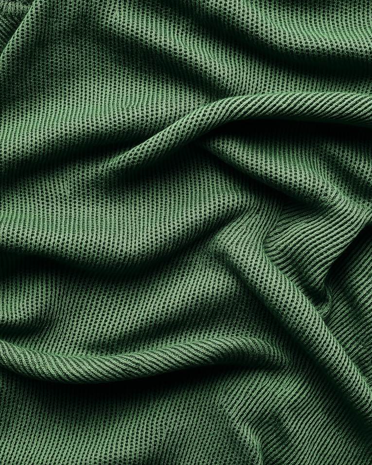 Basil leaf on cream organic cotton fabric, macro still-life, FIOR.