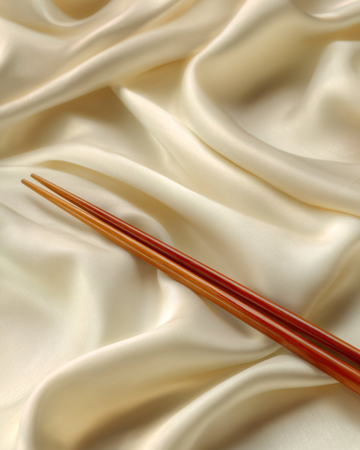 Organic cotton folds with chopsticks on cream background, FIOR Our Story hero