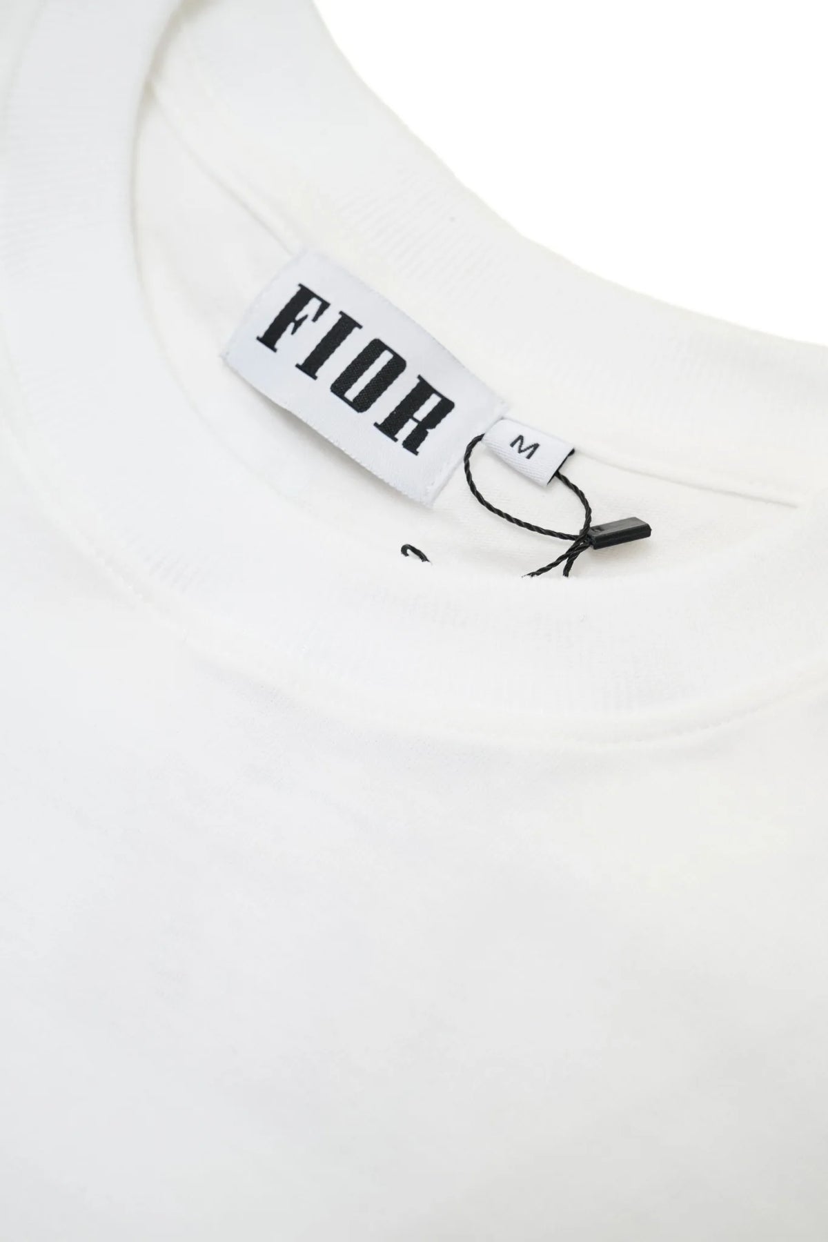 Dettaglio colletto e label FIOR su T-shirt bianca, taglia M